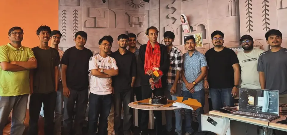 Aadarsh with his M&S Labs colleagues at his farewell, a cake on the table in front of them.